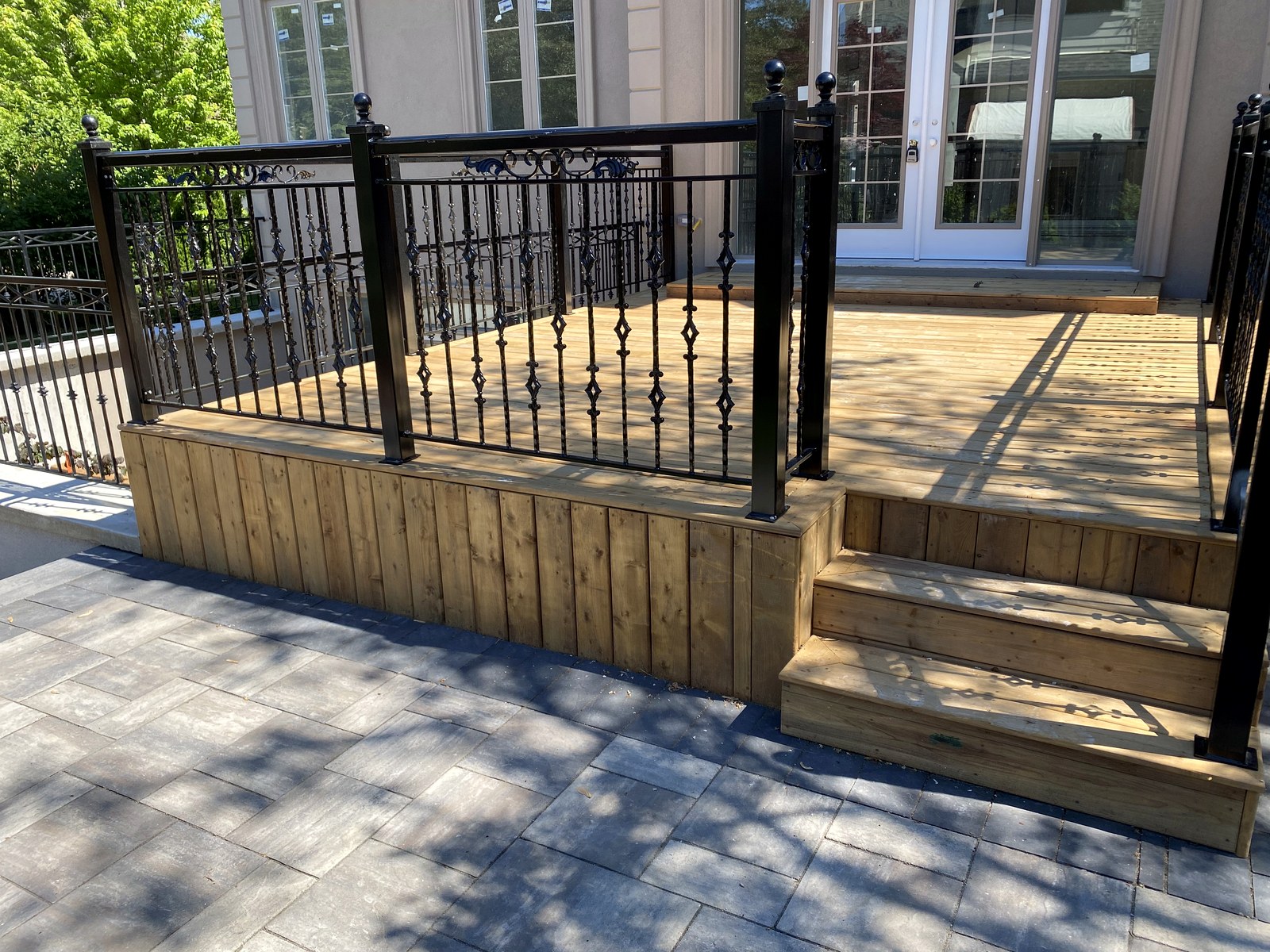 Raised wood deck with black metal railings