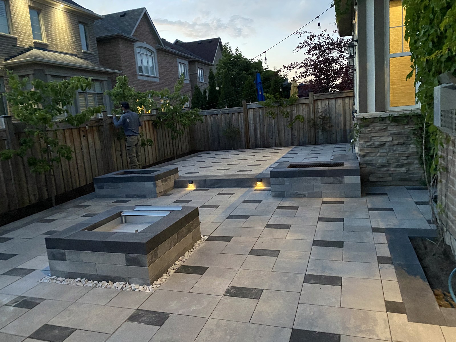 Modern paver patio with built-in seating at dusk